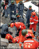 Rescue workers search for victims in the debris of a building that collapsed in the earthquake