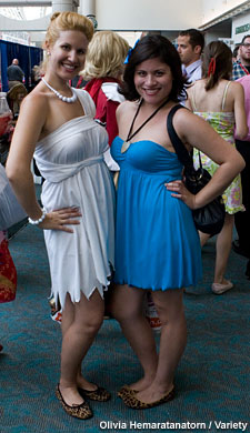 Attendees, such as Wilma Flintstone and Betty Rubble, roam the Comic-Con floor.
